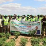 Officials and community members holding the FSRP site handing over banner at an irrigation site in Mandera County
